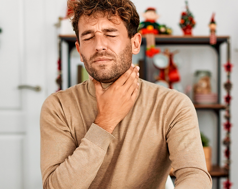 Hombre con dolor de garganta tomando graneodin